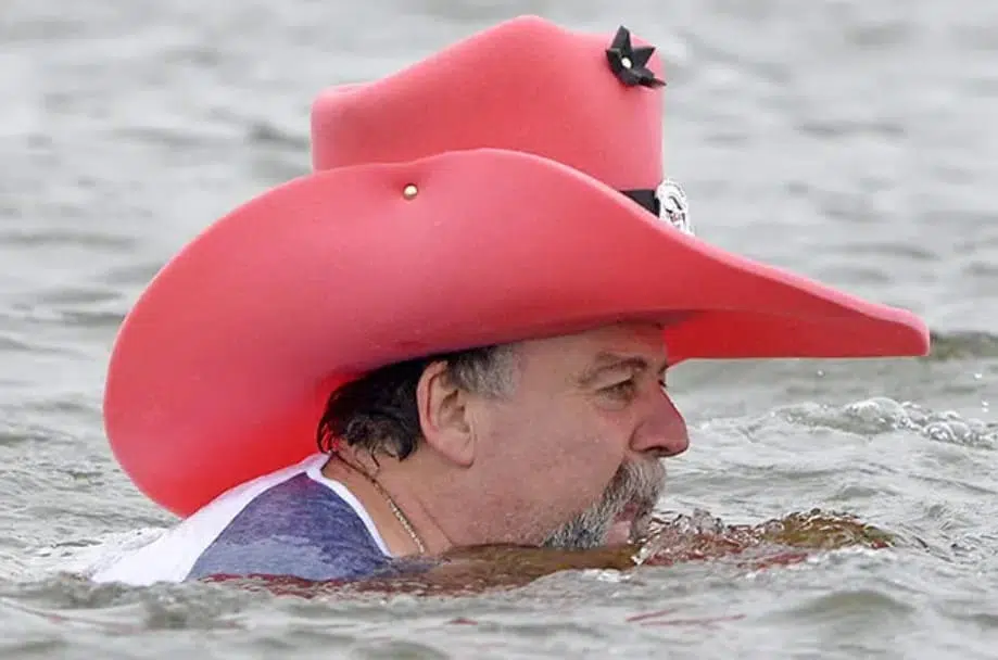 But where's his water pistol? A man in a pink cowboy hat swims in the Elbe river in Dresden, Germany

